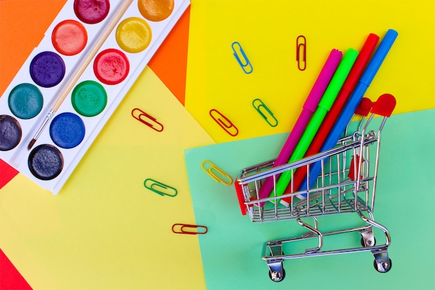 Carrinho de compras com objetos de papelaria. Material escolar e escolar. de volta à escola.