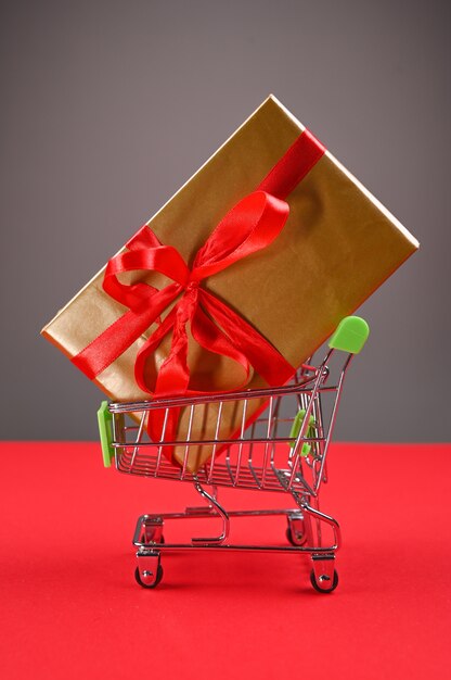Carrinho de compras com presente amarrado com um laço