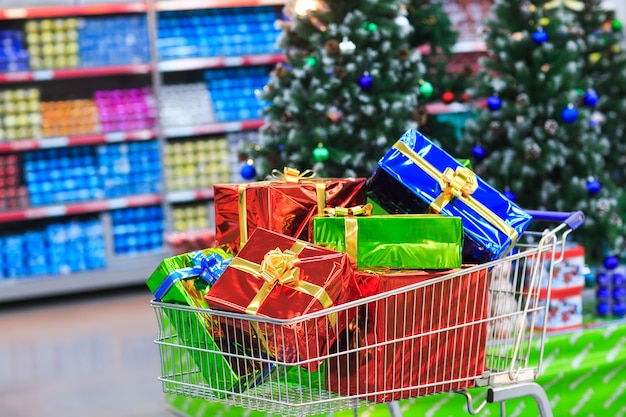 Carrinho de compras com presentes no fundo do supermercado