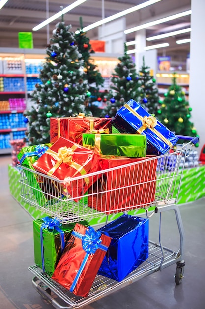 Carrinho de compras com presentes no fundo do supermercado