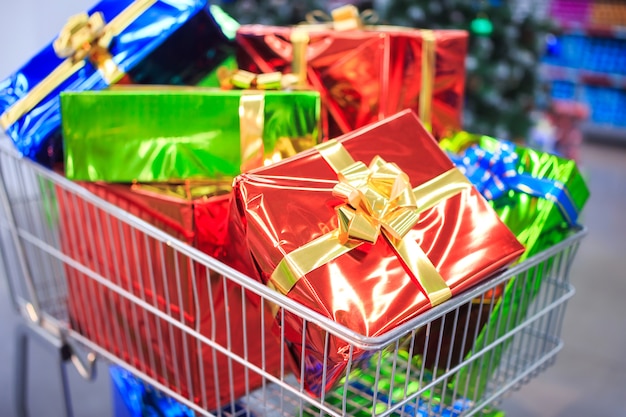 Carrinho de compras com presentes no fundo do supermercado