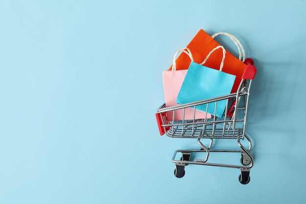 Carrinho de compras com sacolas de papel em azul