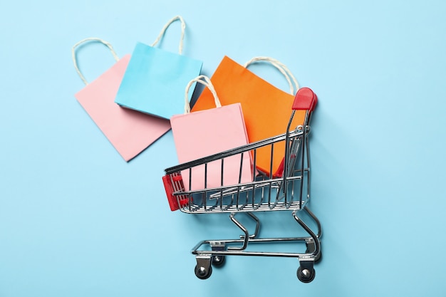 Carrinho de compras com sacolas de papel em azul