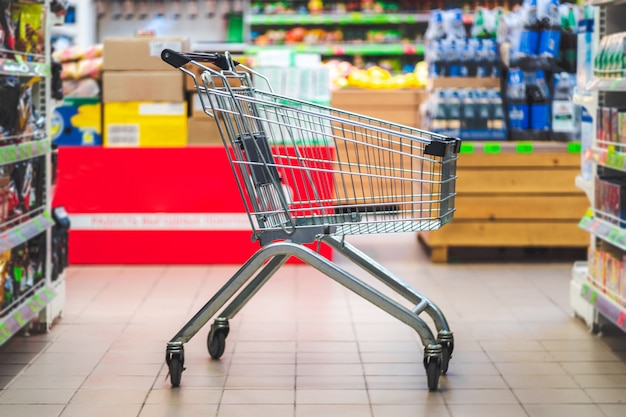 Carrinho de compras no corredor do supermercado. Compra de comida no supermercado.