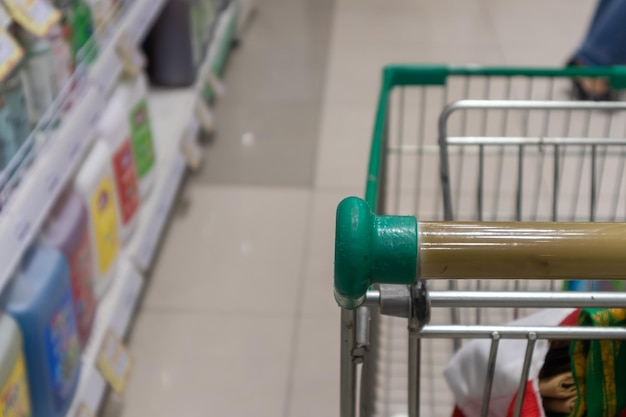 Carrinho de compras verde vazio no corredor do supermercado