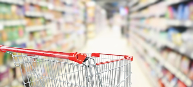 Foto carrinho de compras vermelho vazio no corredor do supermercado