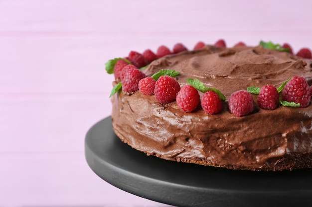 Carrinho de sobremesa com delicioso bolo de chocolate no fundo rosa