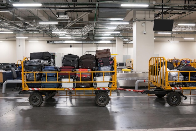 Carrinhos de bagagem com bagagem no compartimento de bagagem do aeroporto