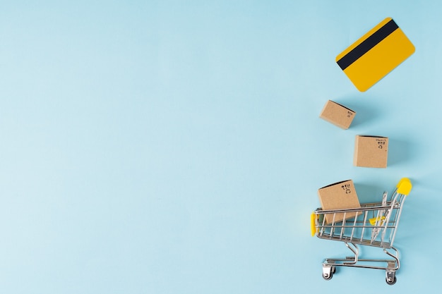 Foto carrito de la compra de juguetes con cajas y tarjeta de crédito con espacio de copia