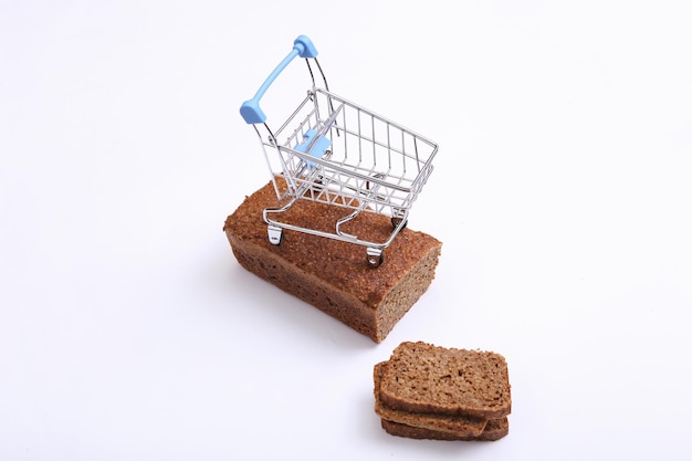 Carrito de la compra con pan de centeno de grano entero en rodajas sobre fondo blanco.