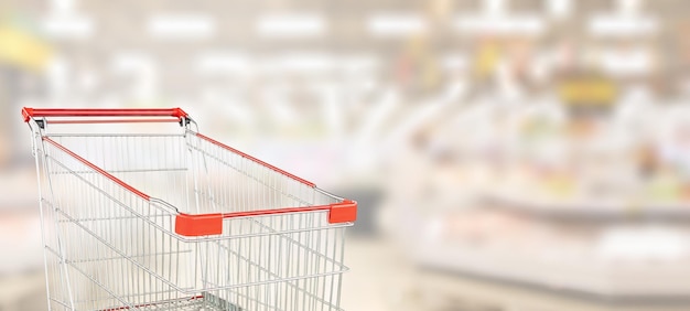 Carrito de la compra rojo vacío en el pasillo del supermercado