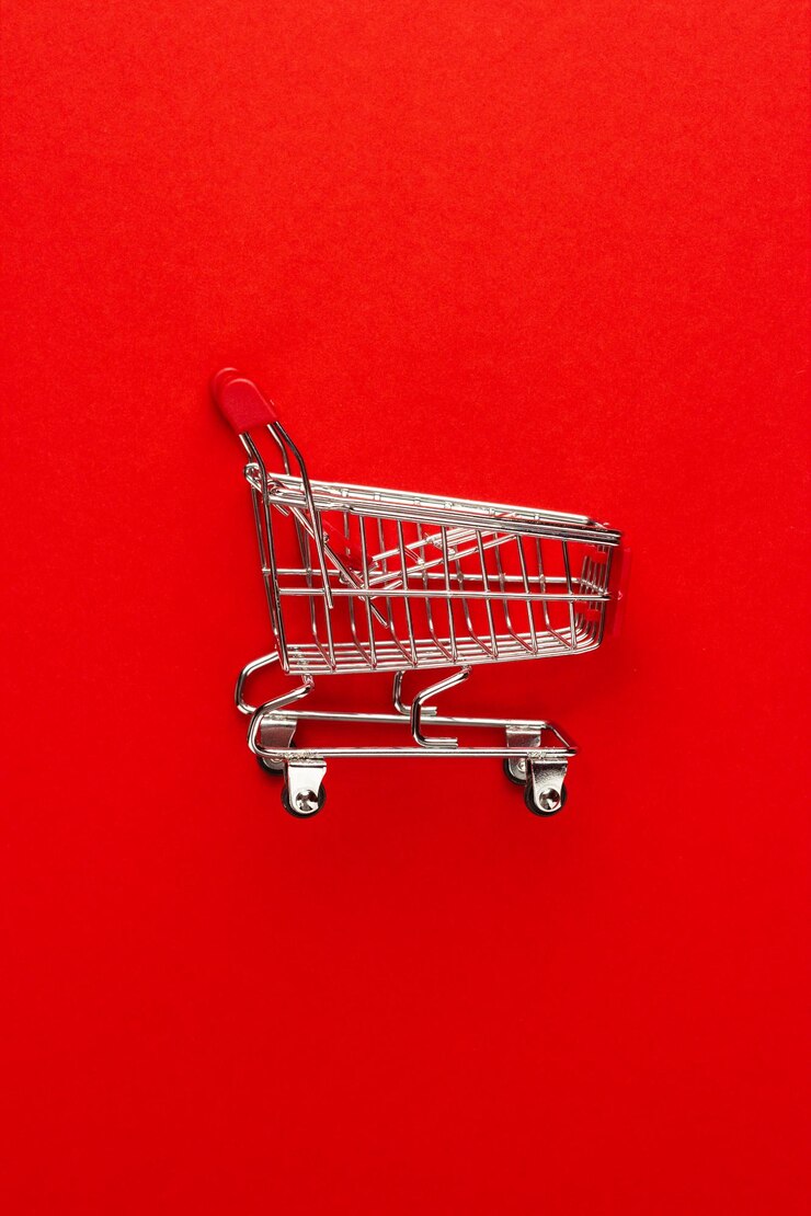 Foto carrito de la compra sobre fondo rojo.