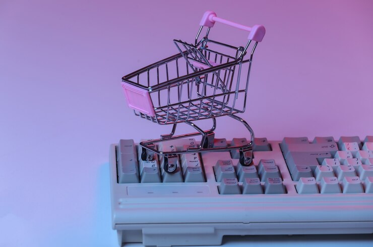 Carrito de la compra en el teclado antiguo de la pc. Neón degradado azul rosa, luz holográfica. Retro compras en línea
