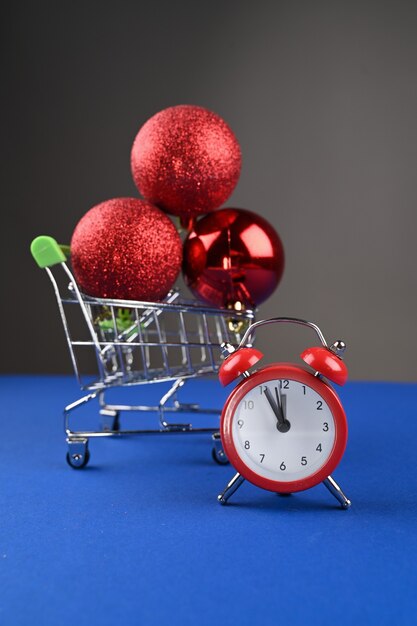 Carrito de compras con bolas de Navidad y un reloj.