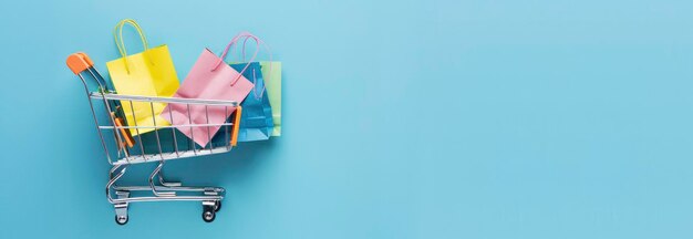 Foto un carrito de compras con bolsas de papel coloridas en un fondo azul claro