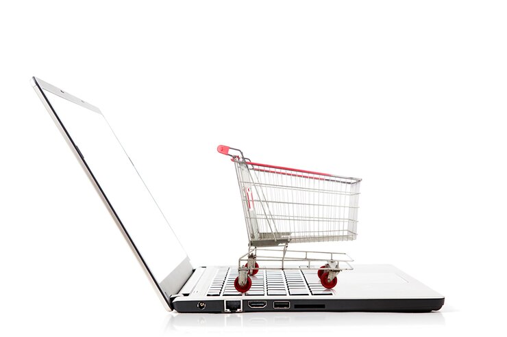 Foto el carrito de compras en la computadora portátil sobre un fondo blanco