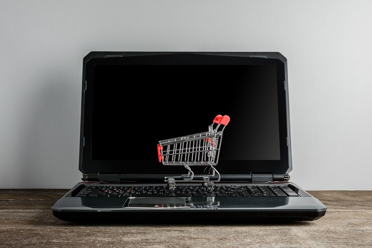 Foto carrito de compras y laptop