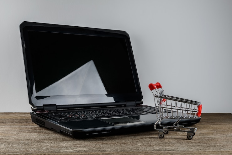 Foto carrito de compras y laptop