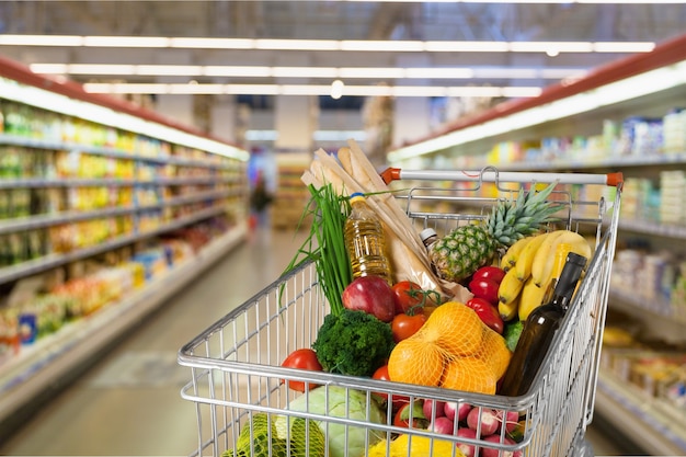 Carrito de compras lleno con varios comestibles.