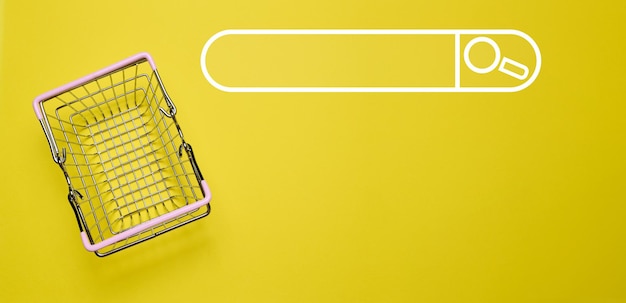 Carrito de compras en miniatura vacío en fondo amarillo vista superior