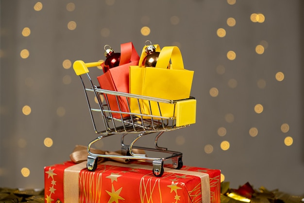 Carrito de compras con paquetes, compras, descuentos y regalos para Navidad y Año Nuevo.