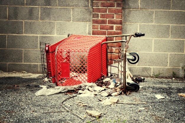 Foto el carrito de compras rojo oxidado en el suelo