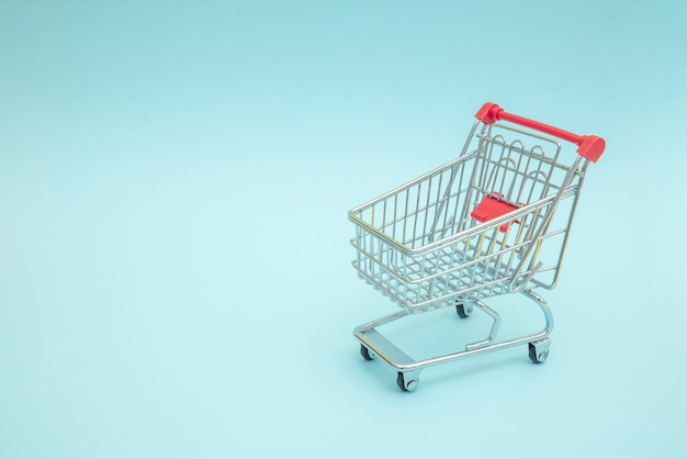 Carrito de compras vacío con fondo azul.