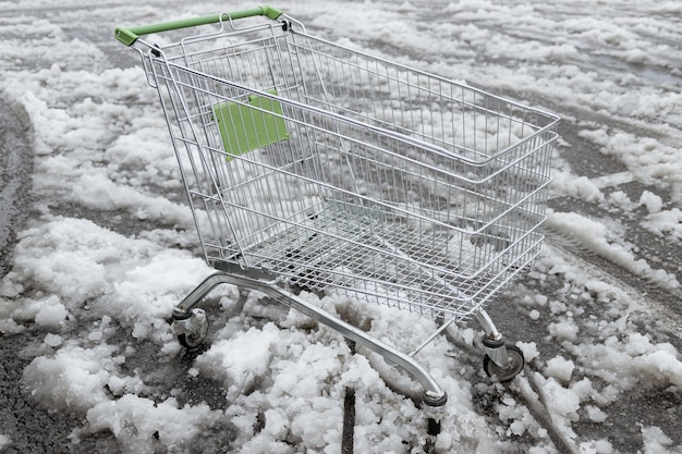 Carrito de compras vacío en la nieve Un carrito de compras abandonado en la nieve