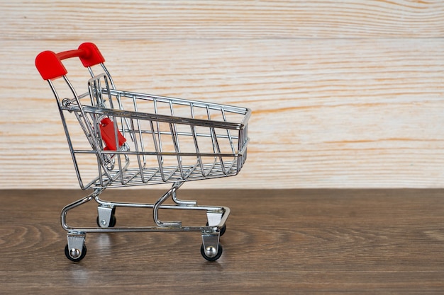 Carrito de compras vacío sobre fondo de madera