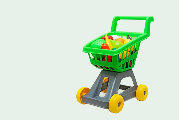 Un carrito de juguete de un supermercado con verduras.