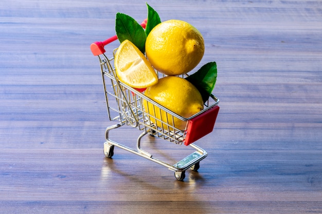 carrito de supermercado con hojas verdes y limón