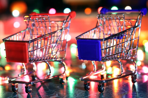 Carrito de supermercado de metal sobre un fondo de luces de colores