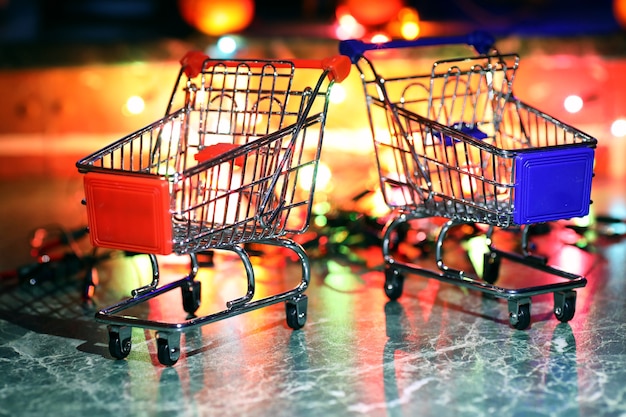 Carrito de supermercado de metal sobre un fondo de luces de colores