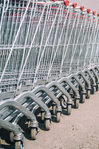 Los carritos del supermercado están en fila. De cerca. Foto vertical