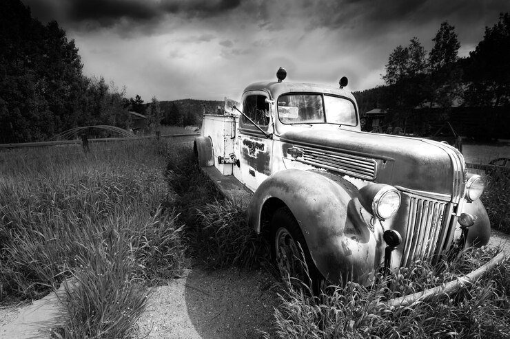 Foto carro abandonado em um campo de grama contra o céu