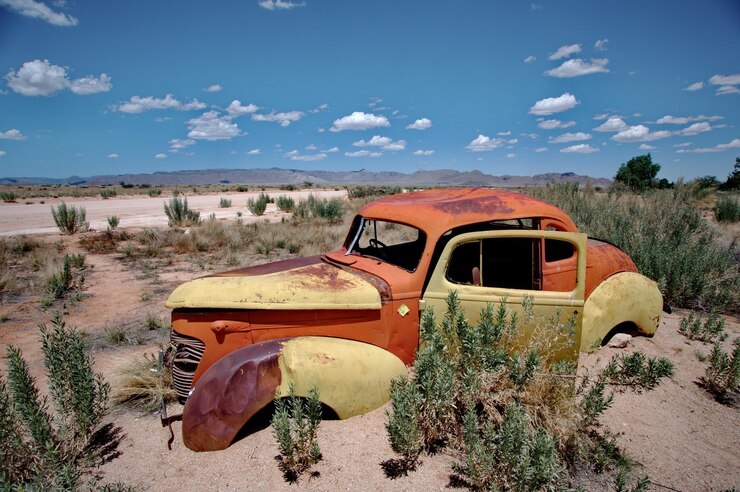 Foto carro abandonado no deserto.