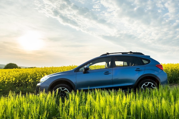 Carro ao nascer do sol no campo agrícola Viajando em auto aventura em expedição de vida selvagem ou viagem extrema em veículo SUV Offroad 4x4 sob o sol claro da manhã