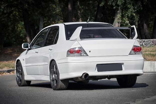 Foto carro branco em um fundo de rua carro esportivo urbano moderno com papel de parede spoiler