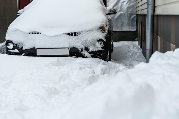 Foto carro coberto de neve durante fortes nevascas