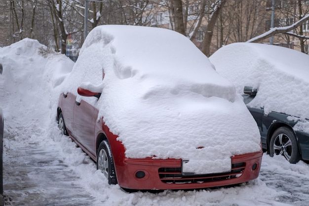 Carro cobriu uma grande camada de neve na rua após uma forte nevasca e nevasca