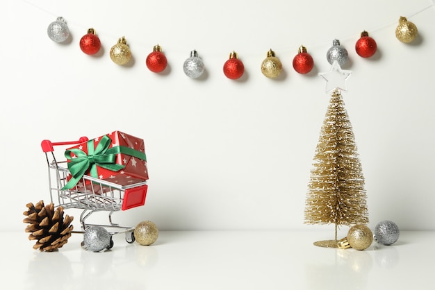 Carro de la compra con caja de regalo y accesorios de Navidad en blanco