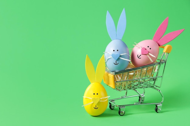 Carro de la compra lleno de huevos de Pascua en concepto de venta de espacio de copia de fondo verde