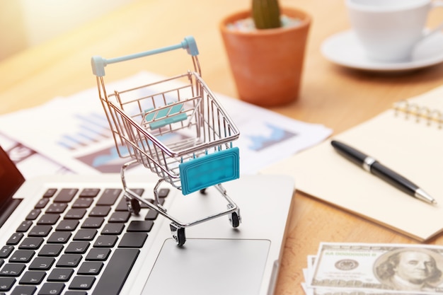 Foto carro de la compra en el teclado del ordenador portátil, compras en línea