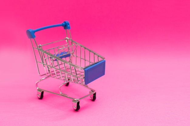 Carro de compras aislado sobre fondo rosa