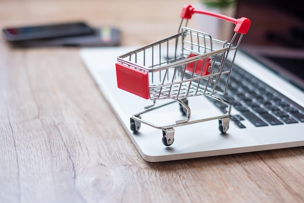 Carro de compras en la computadora portátil en la oficina en casa