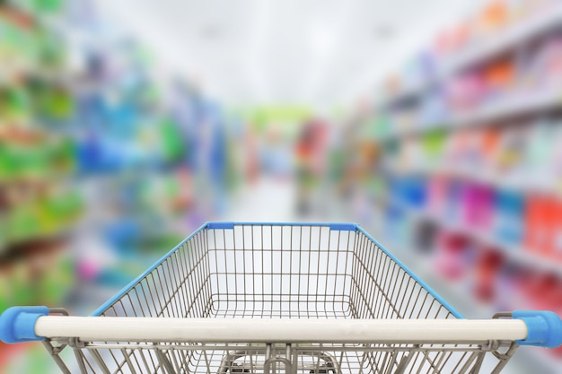 Carro de compras en el fondo del supermercado de desenfoque