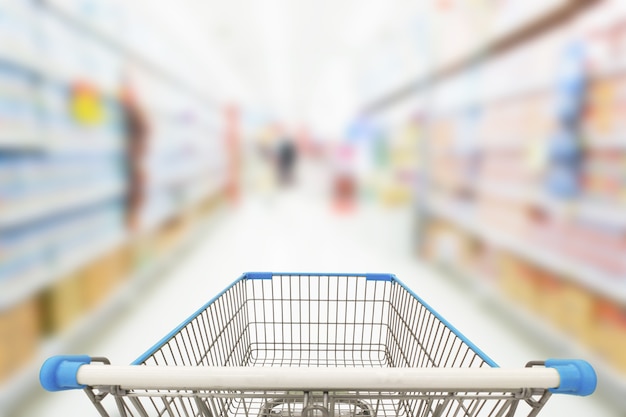 Carro de compras en el fondo del supermercado de desenfoque