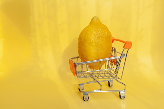 Carro de compras con frutas. limón jugoso amarillo brillante en un carrito de compras de juguetes para productos