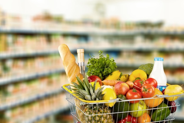 Carro de compras lleno de varios comestibles en la tienda