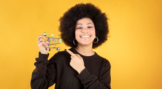 Carro de compras de mujer bastante afro, compras en línea